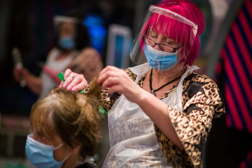 Owner Carole Rickaby cuts customer Sandra Jacobs' hair at Tusk Hair stylists in Camden just after midnight on July 4 (Getty Images)