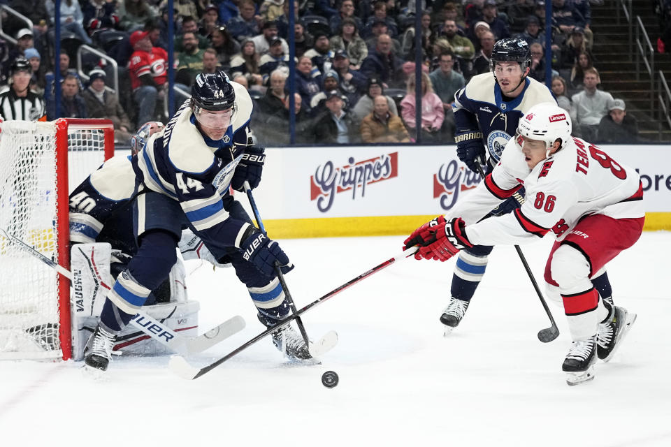 Columbus Blue Jackets defenseman Erik Gudbranson (44) and Carolina Hurricanes left wing Teuvo Teravainen (86) reach for the puck in front of Blue Jackets goaltender Daniil Tarasov (40) in the first period of an NHL hockey game Thursday, Feb. 29, 2024, in Columbus, Ohio. (AP Photo/Sue Ogrocki)