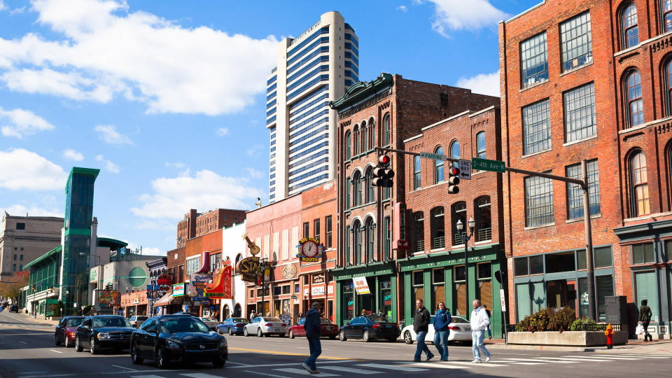 people crossing Broadway Street in Nashville downtown during a bright fall day.