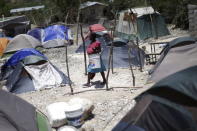 A woman walks near tents at a camp for returned Haitians and Haitian-Dominicans, near the border between the Dominican Republic and Haiti, in Malpasse, August 3, 2015. REUTERS/Andres Martinez Casares