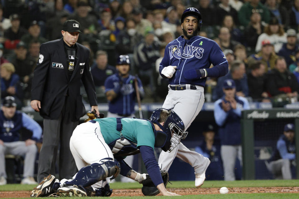 Tampa Bay Rays' Yandy Diaz, right, scores on a Randy Arozarena single as Seattle Mariners catcher Tom Murphy recovers the ball during the second inning of a baseball game Friday, May 6, 2022, in Seattle. (AP Photo/Jason Redmond)