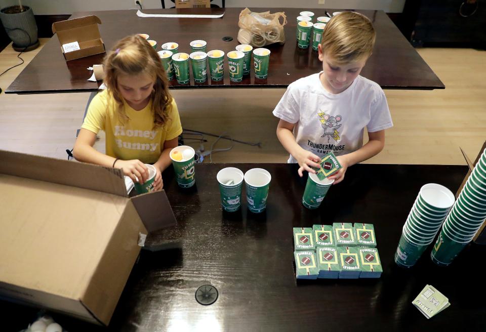 Brother and sister Daphne and Nolan Moore assemble a game that they invented called FUMBLE! on Tuesday, November 1, 2022 in Neenah, Wis. The game is football-themed, combining cards and pong skills. The siblings, through their company ThunderMouse Games, are selling FUMBLE! on Amazon and at retail outlets in the Fox Cities.