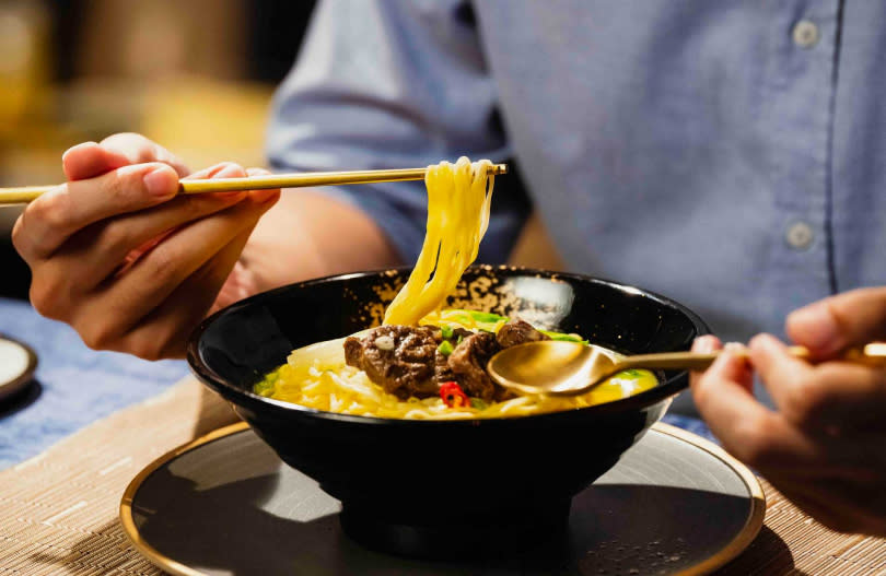 「金牛肉麵」有黃金色的酸辣湯頭，搭配具Q度的非油炸直麵條。（圖／滿漢大餐提供）