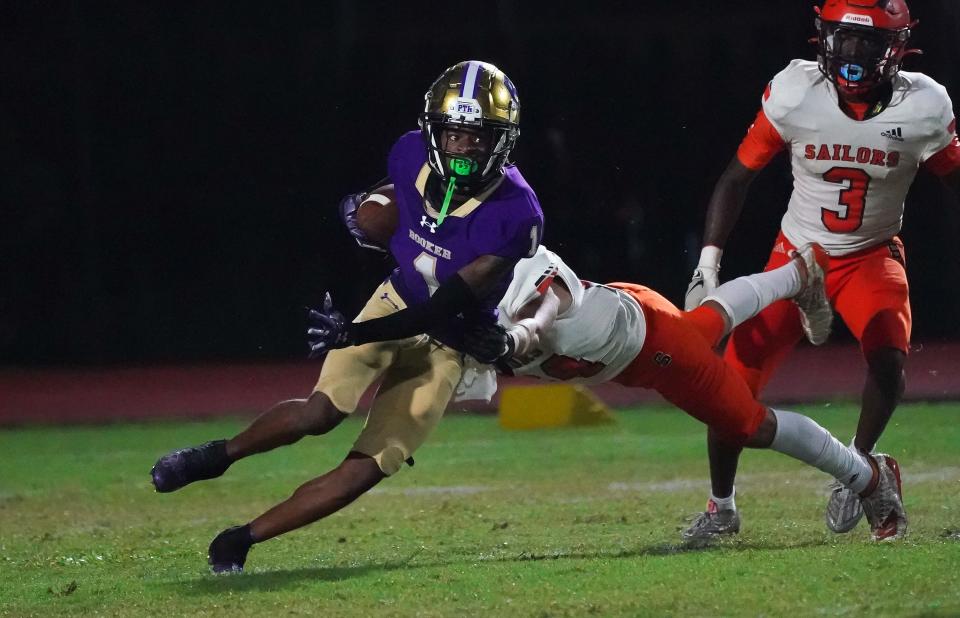 Booker's Josiah Booker is hit by a Sarasota defender during first half action Friday evening.