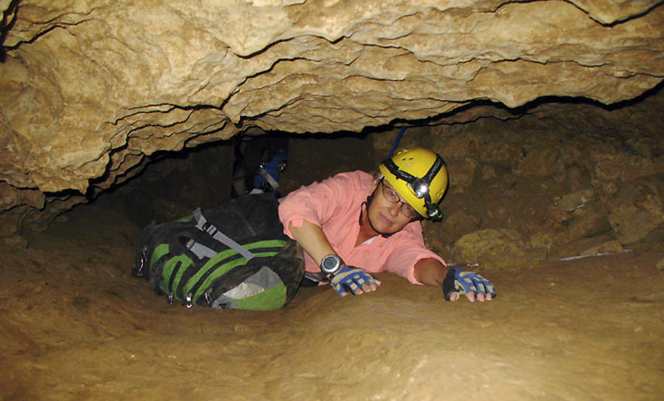 FILE - In this July 3, 2008, file photo, New Mexico Tech professor Penny Boston crawls through the Mud Turtle Passage on the way to the Snowy River formation during an expedition in Fort Stanton Cave, N.M. Boston, who discovered extreme life in New Mexico caves in 2008, presented new findings on Friday, Feb. 17, 2017 of microbes trapped in crystals in Mexico that could be 50,000 years old. (AP Photo/Susan Montoya Bryan)