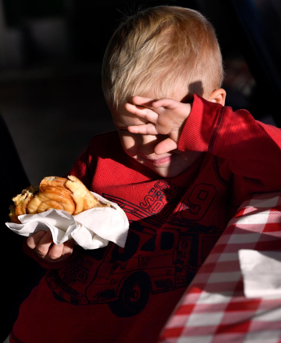 Gunner Hardy, 3, shields his eyes from the sunrise during breakfast with his then-9-year-old brother Austin and their grandfather Ronnie Hardy at an Abilene donut shop in 2020.