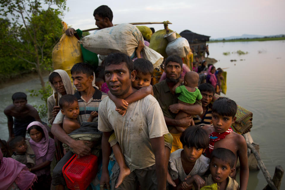 FILE - Rohingya Muslims carry their young children and belongings after crossing the border from Myanmar into Bangladesh, near Palong Khali, Bangladesh, Wednesday, Nov. 1, 2017. Hundreds of thousands of Rohingya refugees on Thursday, Aug. 25, 2022, marked the fifth anniversary of their exodus from Myanmar to Bangladesh, while the United States, European Union and other Western nations pledged to continue supporting the refugees' pursuit of justice in international courts. (AP Photo/Bernat Armangue, File)