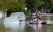 <p>Ellery Forsythe pushes some kids on an air mattress to get a closer look at the submerged vehicles on a Waseca street, Thursday, Sept. 22, 2016, in Waseca, Minn. (Elizabeth Flores/Star Tribune via AP)</p>