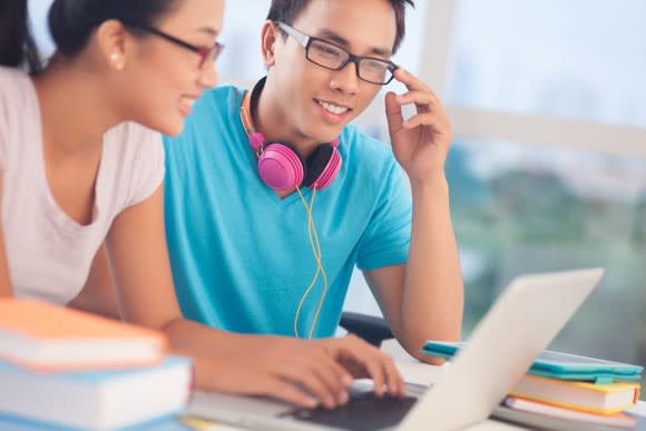 College students surfing the internet on a laptop.