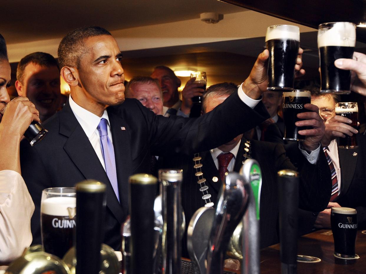 Barack and Michelle Obama drinking Guinness beer pints in an Irish pub.