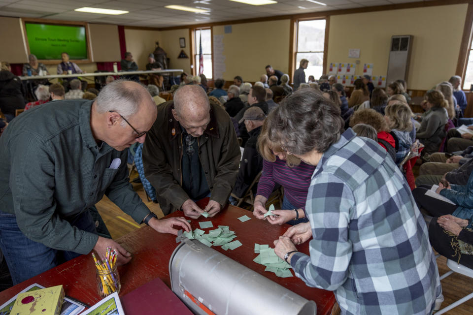 Residents count votes for a cemetery commission position at the annual Town Meeting in Elmore, Vt., Tuesday, March 5, 2024. Across the United States, people are disgusted with politics. Many feel powerless and alienated from their representatives at every level. The tone long ago became nasty, and many feel forced to pick a side and view those on the other side as adversaries. But in pockets of New England, democracy is done a bit differently. One day each year, townsfolk gather to hash out local issues. They talk, listen, debate, vote. And in places like Elmore, once it's all over, they sit down together for a potluck lunch. (AP Photo/David Goldman)