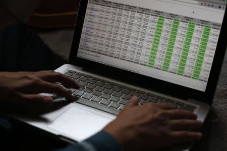 Ainun Najib, an Indonesian IT consultant based in Singapore, shows a table of voting results that was used in his work on the Indonesian elections as he waits to break fast at a friend's house during Ramadan in Singapore July 26, 2014. REUTERS/Edgar Su