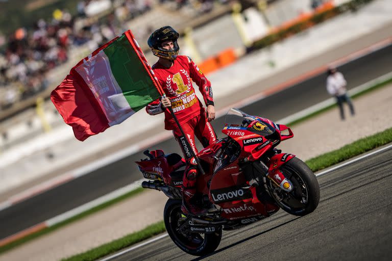 Francesco Bagnaia luce el N°1 en su pecho y la bandera de Italia, sobre la Ducati, durante la vuelta de honor en Cheste; el italiano ensayó una remontada espectacular en la segunda parte de la temporada y se consagró campeón de MotoGP