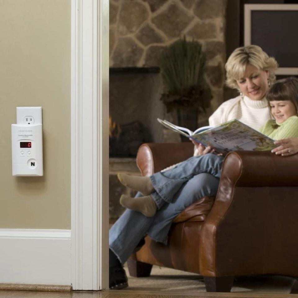 Woman reading to child near carbon monoxide detector