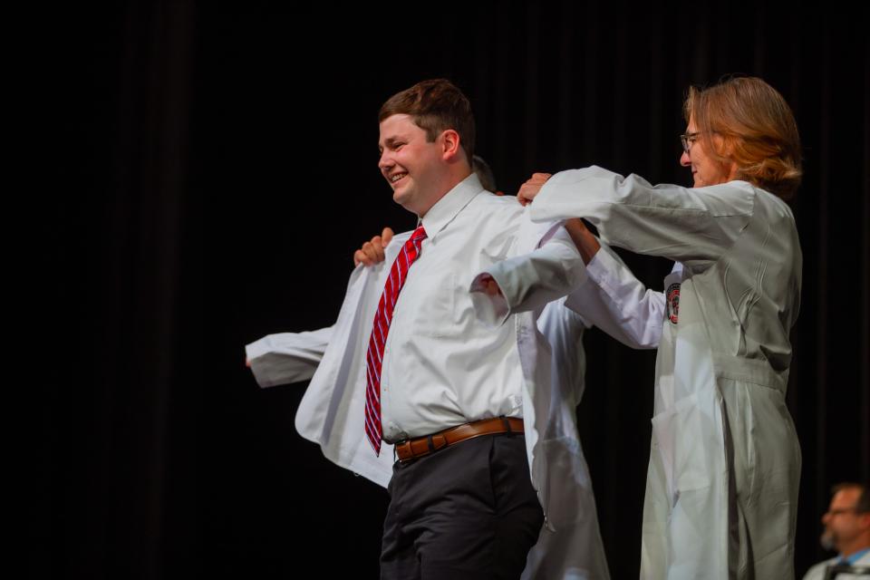 Landon Bernier of Amarillo dons his white coat at Friday's ceremony held by the Texas Tech University Health Sciences Center at the Buddy Holly Hall of Performing Arts and Sciences in Lubbock.