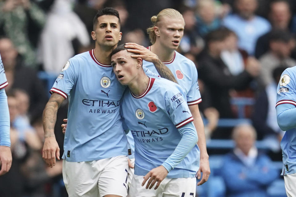 Manchester City's Phil Foden, right, celebrates with his teammate Joao Cancelo after scoring his side's first goal during the English Premier League soccer match between Manchester City and Brentford, at the Etihad stadium in Manchester, England, Saturday, Nov.12, 2022. (AP Photo/Dave Thompson)