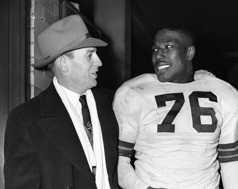 FILE - In this Dec. 19, 1948, file photo, Cleveland Browns fullback Marion Motley, right, stands with coach Paul Brown after a football game against Buffalo in Cleveland. Brown never saw color, and in 1946 he recruited Motley and Bill Willis for his Cleveland team in the All-America Football Conference. (AP Photo/Harold Valentine, File)