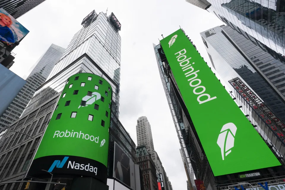 Electronic screens in New York's Times Square announce the Robinhood IPO, Thursday, July 29, 2021. Robinhood has already changed how people trade stocks and who's doing it. Now its sights are on the rest of the financial industry. (AP Photo/Mark Lennihan)