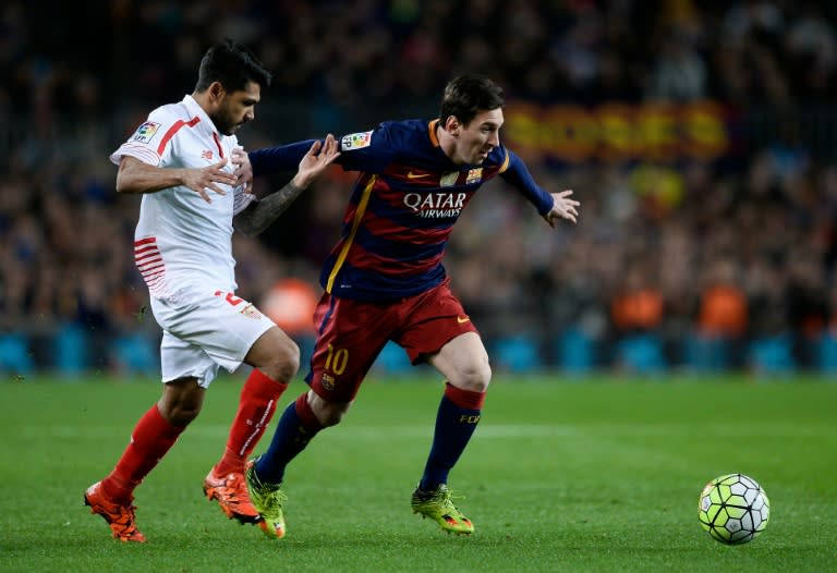 Sevilla's defender Benoit Tremoulinas (L) vies with Barcelona's forward Lionel Messi during the Spanish league football match at the Camp Nou stadium in Barcelona on February 28, 2016