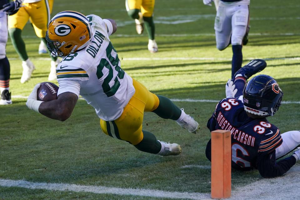 Green Bay Packers' AJ Dillon runs for a touchdown past DeAndre Houston-Carson (36) during the second half of an NFL football game Sunday, Dec. 4, 2022, in Chicago. (AP Photo/Charles Rex Arbogast)