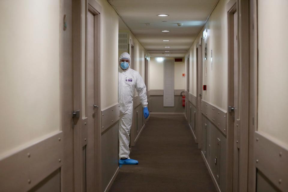 A medical staff of the Gemelli hospital stands at the door of a room of the Pineta Palace Hotel where patients recovering from COVID-19 are undergoing quarantine under the supervision of the Gemelli hospital, in Rome, Saturday, Nov. 14, 2020.