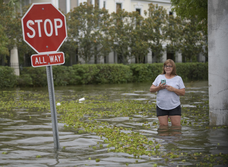 Sheri Bordelon checks out the storm surge from Lake Pontchartrain on Lakeshore Drive in Mandeville, La., Saturday, July 13, 2019. Mandeville is on the north shore of the lake while New Orleans is on the south shore. The waves are caused by the wind and storm surge from Hurricane Barry in the Gulf of Mexico. (AP Photo/Matthew Hinton)