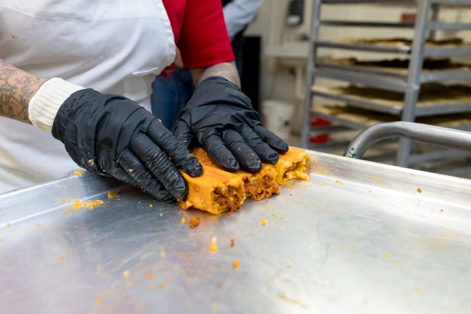 María Treviño, an employee at Food City Supermarket in El Paso, Texas, arranges the red pork tamales on trays to cool off after they have been steamed on Tuesday, Dec. 19, 2023.