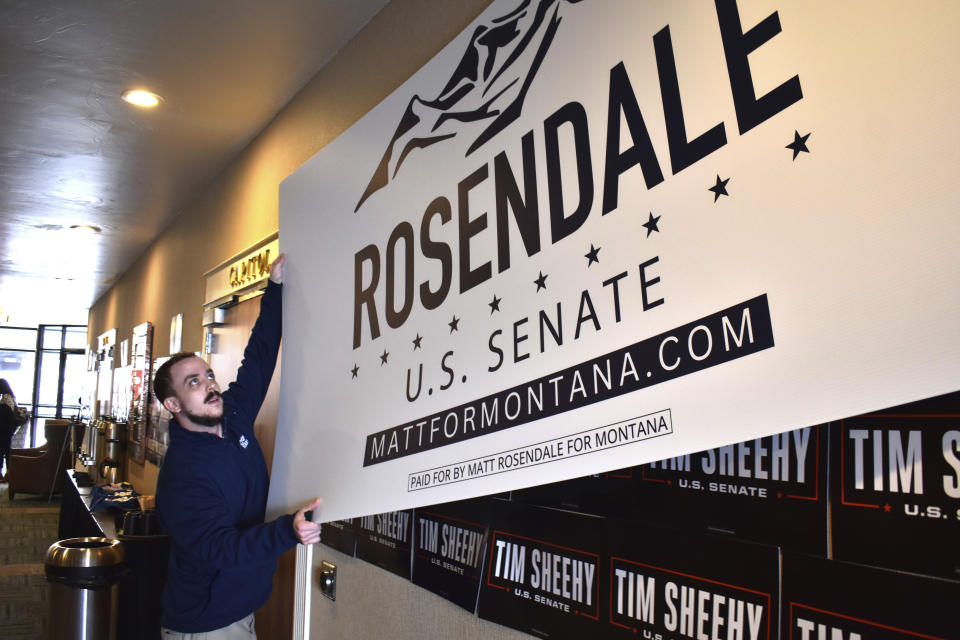 Campaign volunteer Joey Grewell is seen putting up a sign for Montana Rep. Matt Rosendale's U.S. senate campaign during a Republican gathering, Friday, Feb. 9, 2024, in Helena, Mont. Rosendale is facing off against political newcomer and former U.S. Navy SEAL Tim Sheehy. (AP Photo/Matthew Brown)