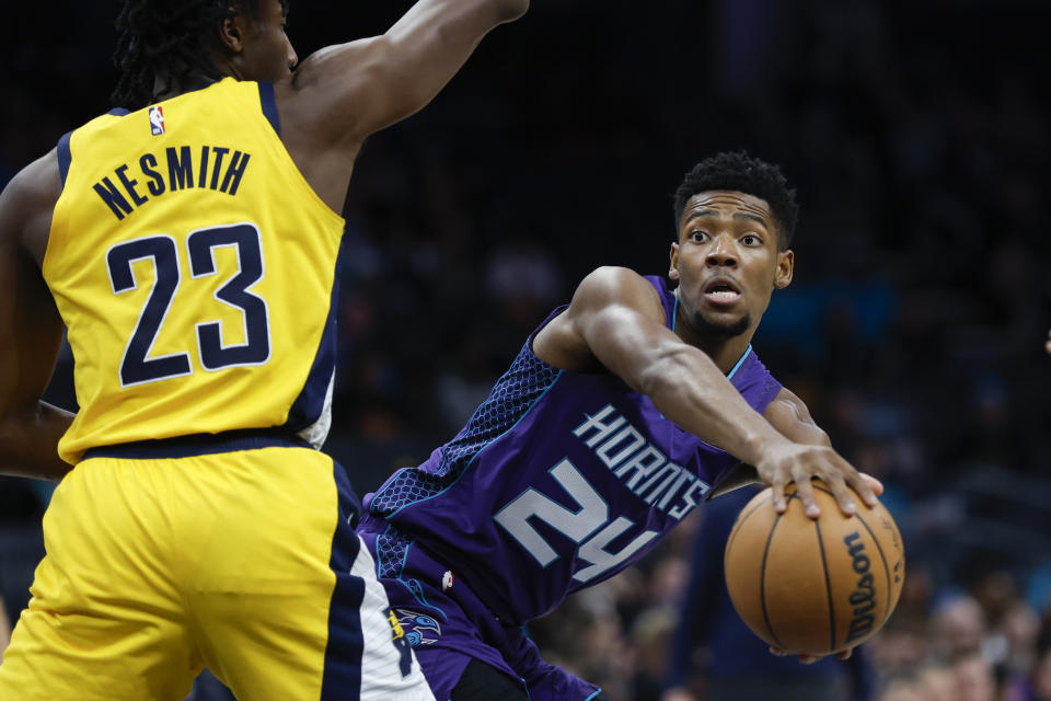 Charlotte Hornets forward Brandon Miller (24) looks to pass the ball around Indiana Pacers forward Aaron Nesmith (23) during the first half of an NBA basketball game in Charlotte, N.C., Monday, Feb. 12, 2024. (AP Photo/Nell Redmond)