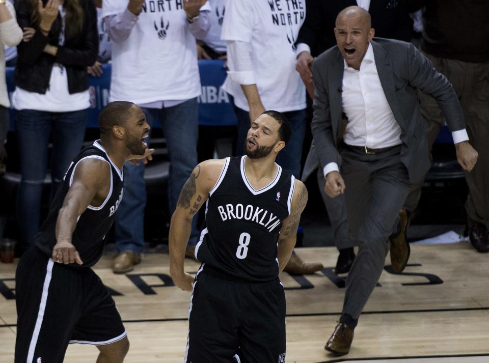 Brooklyn Nets teammates Alan Anderson, left, Deron Williams (8) and head coach Jason Kidd, right, react after they defeated the Toronto Raptors in Game 7 of the opening-round NBA basketball playoff series in Toronto, Sunday, May 4, 2014. (AP Photo/The Canadian Press, Nathan Denette)