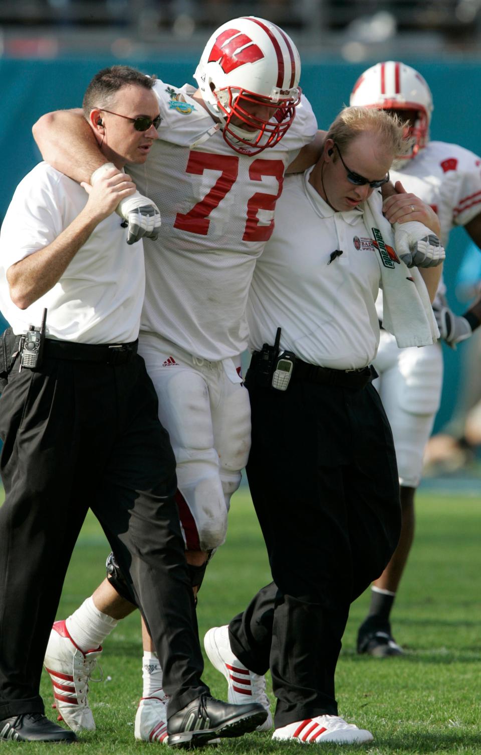 Wisconsin's Joe Thomas is helped off the field after hurting his knee playing on the defensive line for the Badgers on Jan. 2, 2006, in the Capital One Bowl.