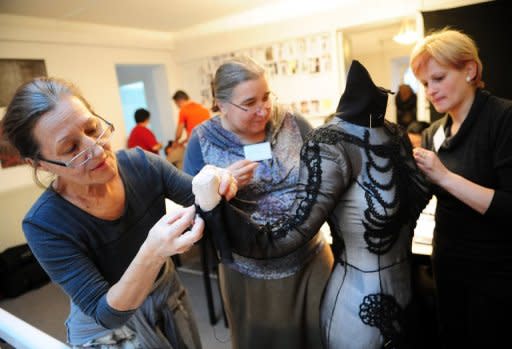 Romanian artisans put the finishing touches to a dress by French designer Philippe Guilet during the final preparations for the fashion event called "100%.RO" held at the French embassy headquarters in Bucharest. Sheepskin skirts and bead-embroidered dresses shone on the catwalk in a one-of-a-kind ethnic fashion show bringing together the skills of the French designer and of Romanian handicrafts