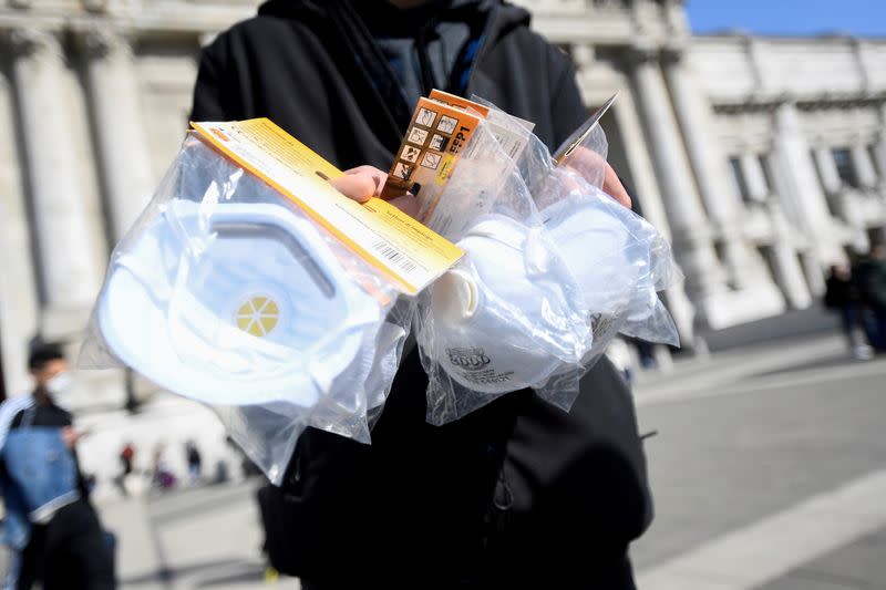 A street vendor sells face masks outside the central railway station in Milan