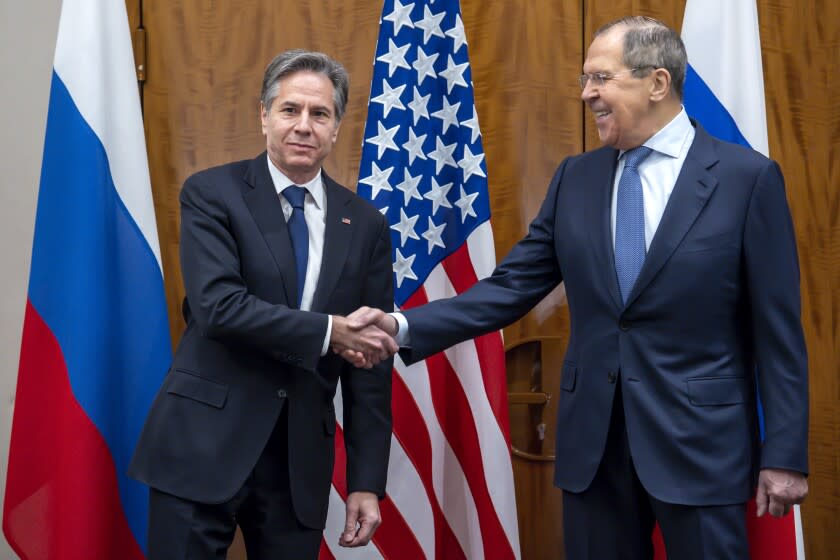 U.S. Secretary of State Antony Blinken, left, shake hands with Russian Foreign Minister Sergei Lavrov, right, prior to their meeting in Geneva, Switzerland, Friday, Jan. 21, 2022. (Martial Trezzini/Keystone via AP)