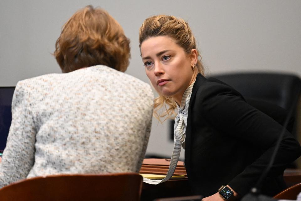 US actress Amber Heard speaks to her attorney at the Fairfax County Circuit Courthouse in Fairfax, Virginia, on April 19, 2022. - US actor Johnny Depp is suing ex-wife Heard for libel after she wrote an op-ed piece in The Washington Post in 2018 referring to herself as a public figure representing domestic abuse. (Photo by Jim WATSON / POOL / AFP) (Photo by JIM WATSON/POOL/AFP via Getty Images)