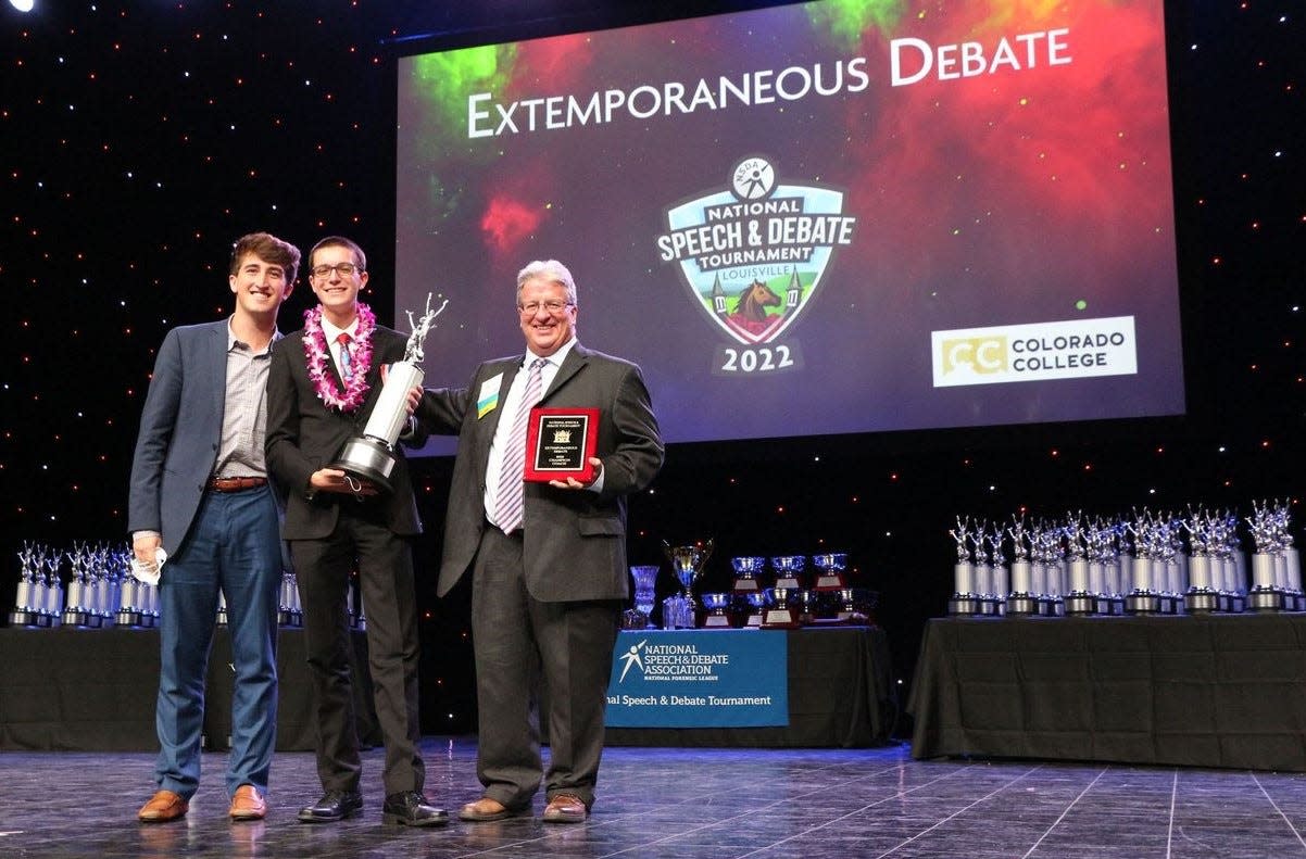 Alliance High's Jordan Schwartz, center, holds the trophy he received for winning the extemporaneous debate category in the National Speech & Debate Tournament in June in Kentucky. Schwartz is with Bob Duncan, right, the Debate Team coach at Alliance High School; and Robert Duncan, left, a Louisville High School graduate and son of Bob, who also served as a coach for Schwartz during the national championship event.