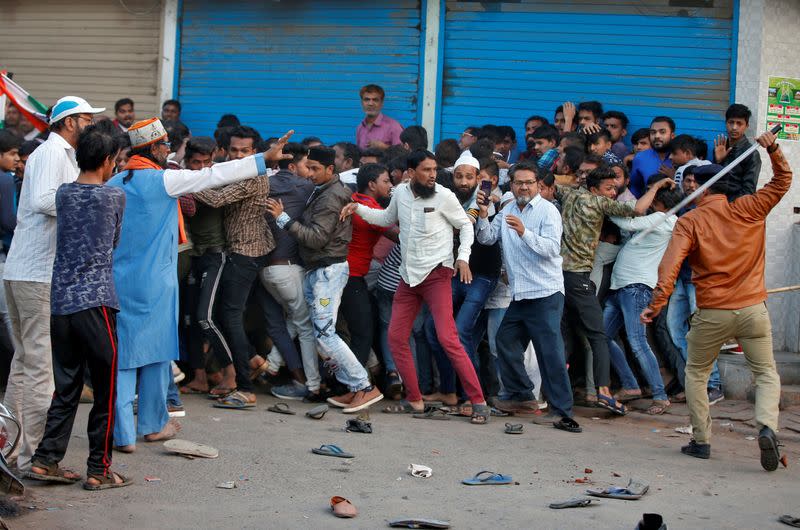 A policeman wields a stick against demonstrators during a protest against a new citizenship law, in Ahmedabad