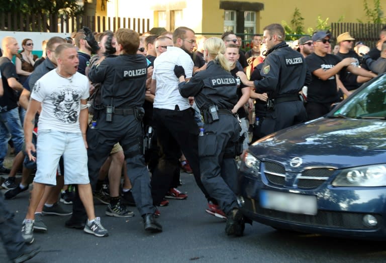 Members of German far-right party NPD scuffle with police during a demonstration against the arrival of refugees on July 24, 2015 in Dresden, eastern Germany