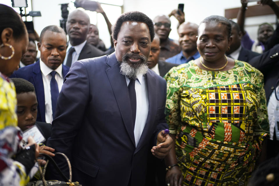 Congolese President Joseph Kabila, center, leaves the polling station after casting his vote Sunday Dec. 30, 2018 in Kinshasa, Congo. Forty million voters are registered for a presidential race plagued by years of delay and persistent rumors of lack of preparation. (AP Photo/Jerome Delay)