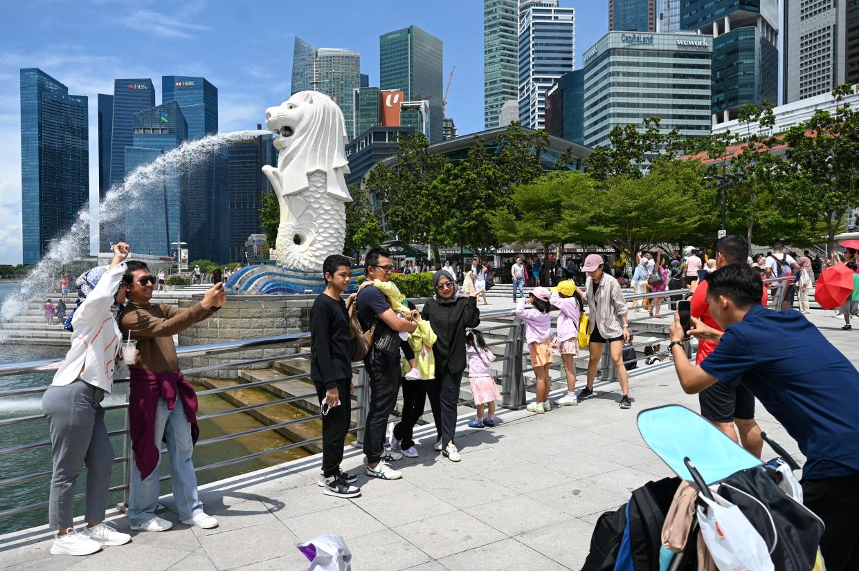 People taking pictures in front of the Merlion Statue at Marina Bay in Singapore.