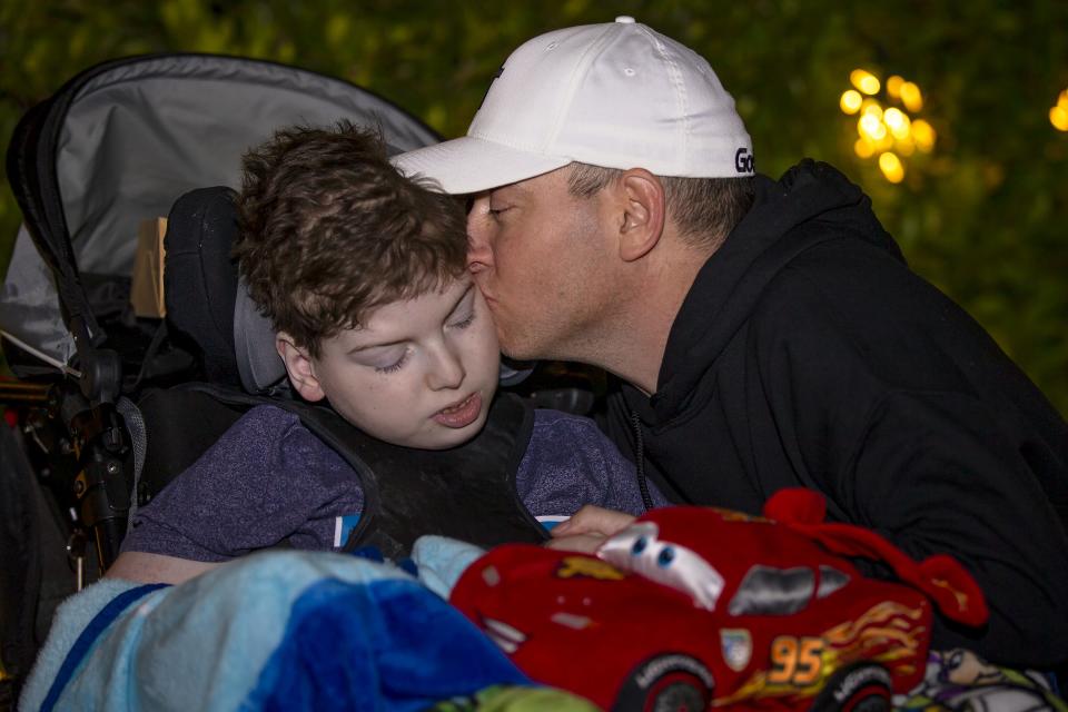 Gordon Wickert kisses the cheek of his son, Andrew, after meeting with Santa Claus during Sensitive Santa event at Christ's Church of the Valley in Peoria on Dec. 2, 2021.