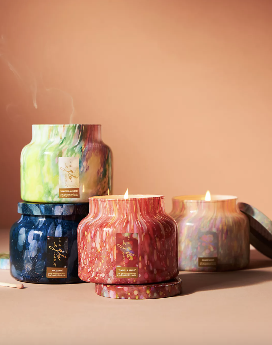 Capri Blue All A Glow Petite Glass Jar Candle in blue, green, red, and pink (Photo via Anthropologie)