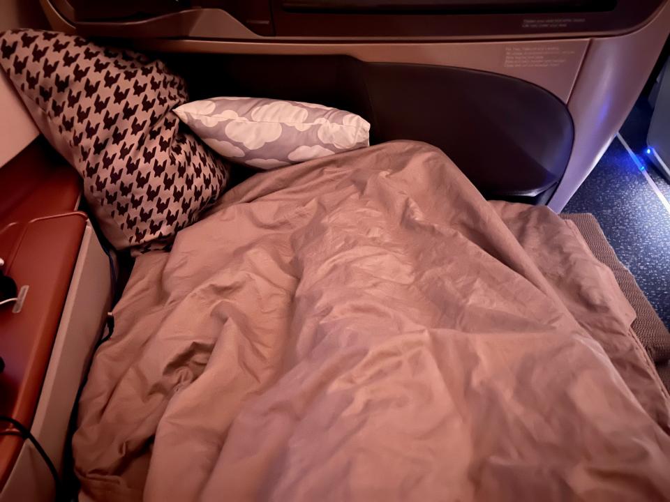 The author laying on the bed, with pillows at the base.