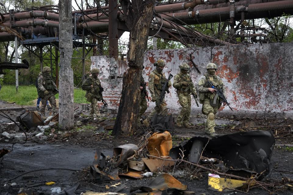 FILE - Russian troops walk in a destroyed part of the Illich Iron & Steel Works Metallurgical Plant in Mariupol, in territory under the government of the Donetsk People's Republic, eastern Ukraine, May 18, 2022. President Vladimir Putin is likely to win another six-year term easily in an election expected in March, using his sweeping grip on Russia’s political scene to extend his tenure of over two decades in power. But he faces daunting challenges. (AP Photo/File)