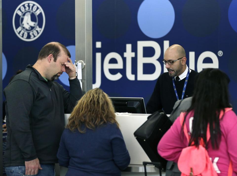 A traveler holds his forehead while waiting to rebook a cancelled JetBlue flight, Monday, Jan. 6, 2014, in Boston. JetBlue announced that they would halt operations in Boston, New York and New Jersey later in the afternoon, to rest their crews and give it time to service aircraft, due to flight delays and cancellations. Heavy rains in the East, and sub-zero temperatures in the Midwest, threw airlines and travel plans into havoc. (AP Photo/Charles Krupa)