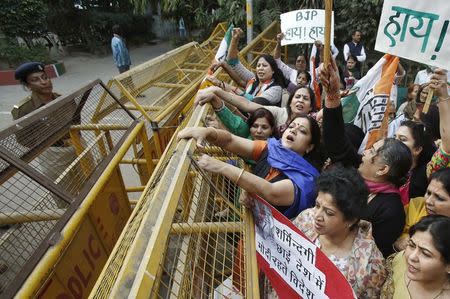 Members of All India Mahila Congress, women's wing of Congress party, shout slogans and carry placards next to a police barricade during a protest against the rape of a female passenger, in New Delhi December 8, 2014. REUTERS/Anindito Mukherjee