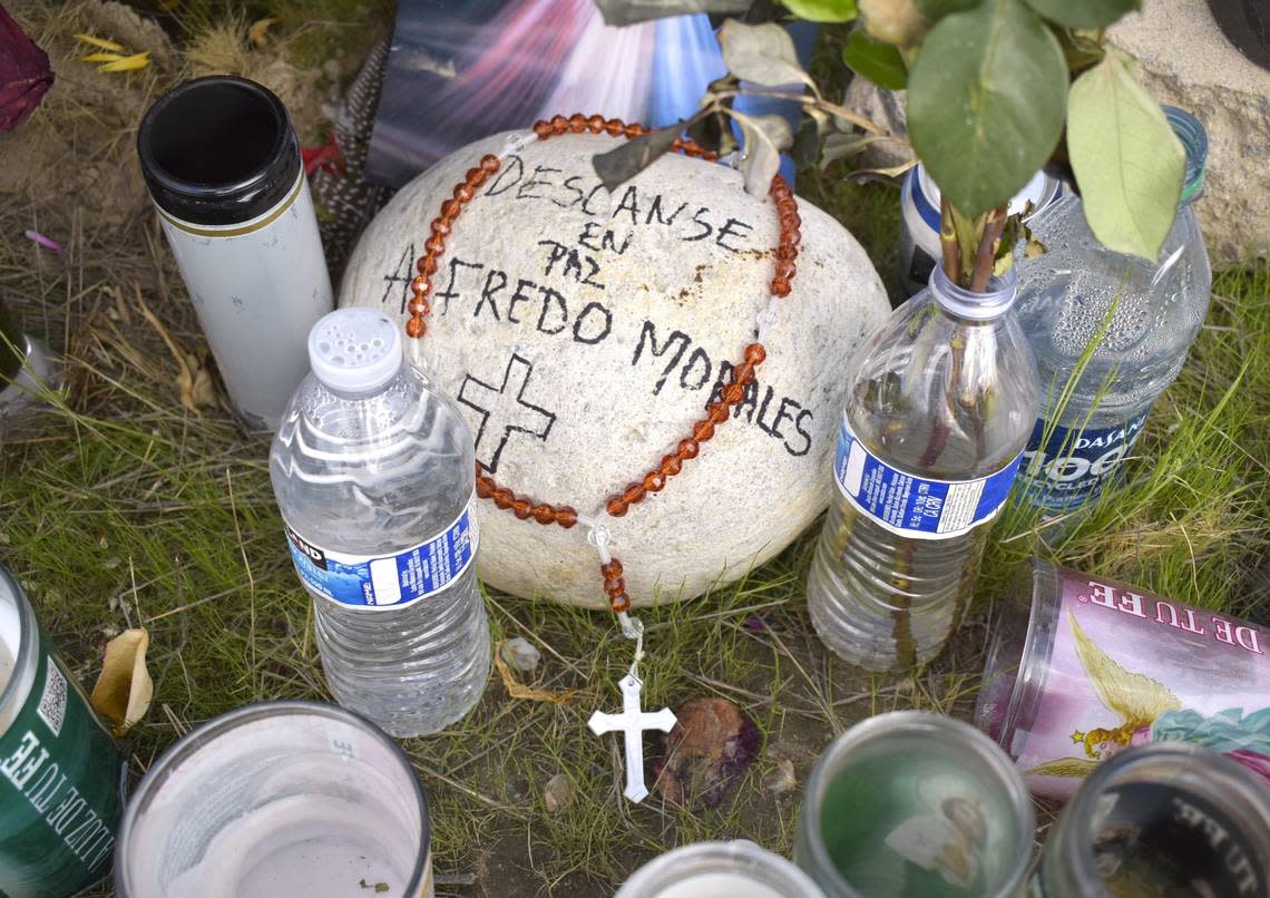 A stone adorned with a Catholic rosary prayer necklace sits at the base of the memorial for farm workers in Madera. It is dedicated to Alfredo Sanchez Morales, 30, who was originally from the Mexican state of Guerrero.