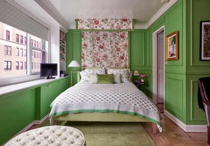 Floral canopy over bed in green bedroom.