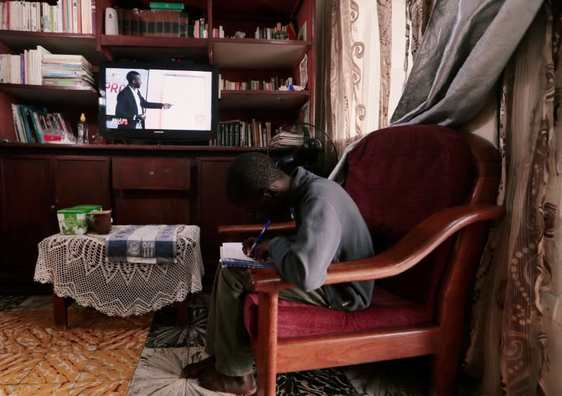 Ibrahima Diongue, 11, sits at home as he attends a math class broadcasting by a local TV channel, after the government ordered all educational establishments to close, one of the several new measures to control the spread of coronavirus disease in Dakar