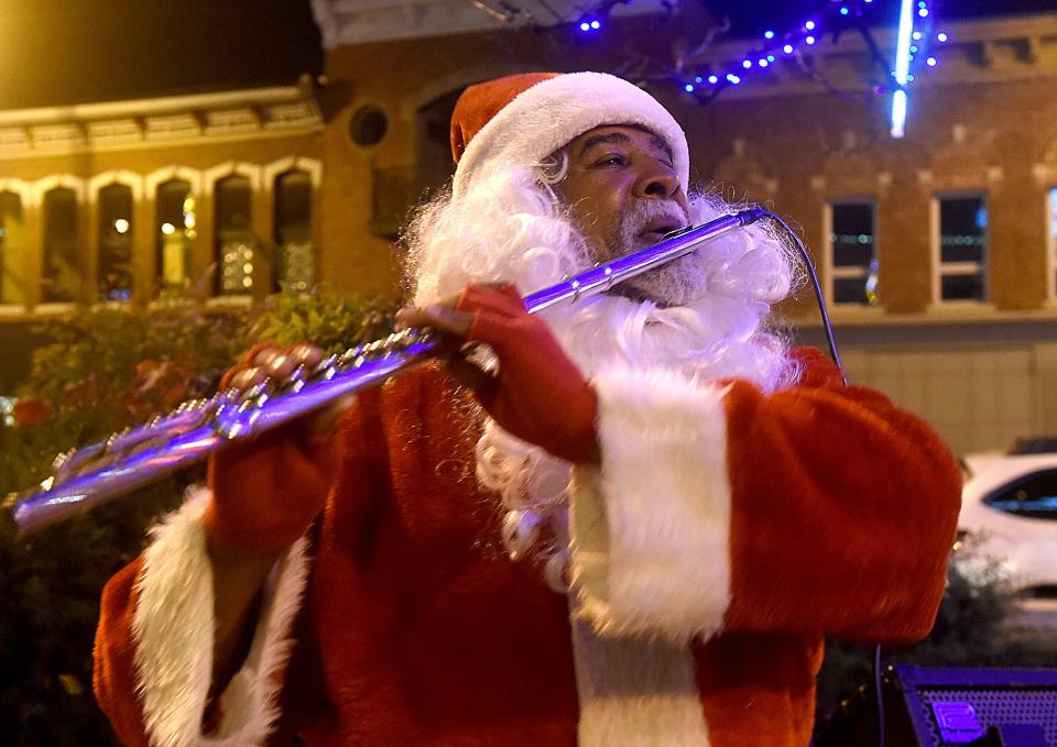 Lamar Roberts, dressed as Santa Claus, plays an electric flute downtown December 2021 during the Living Windows Festival. This year's event is 6 p.m. Dec. 1. Downtown businesses also are preparing for Small Business Saturday on Nov. 25.